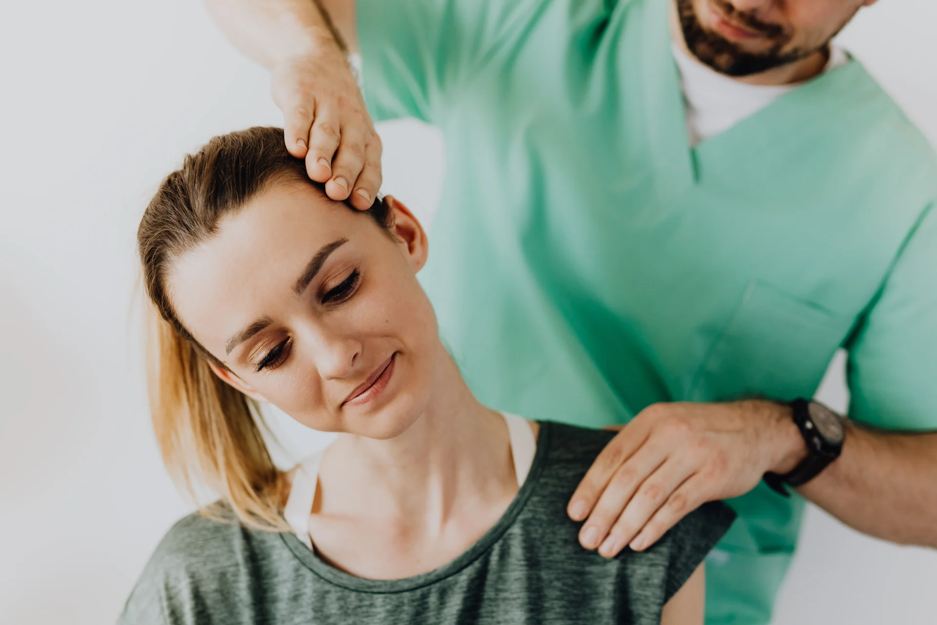 Practitioner assessing a woman’s neck and shoulder